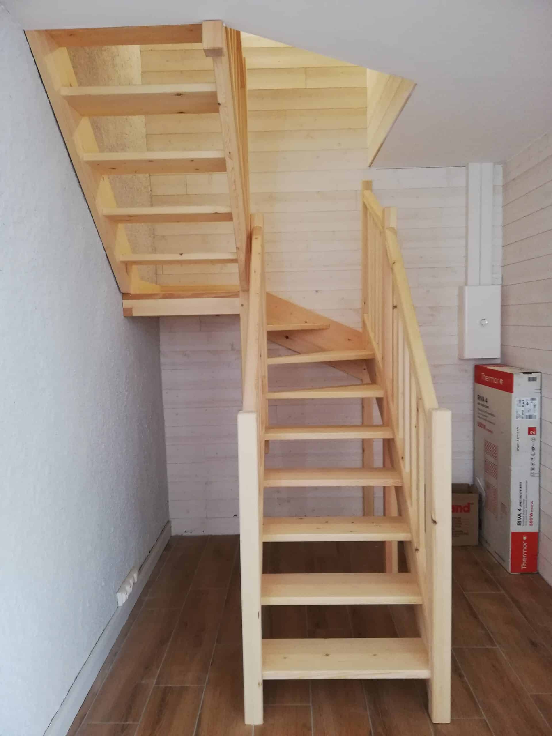 Escalier quart tournant en bois clair massif devant un mur en lambris blanc et un carton Thermor Riva 4.